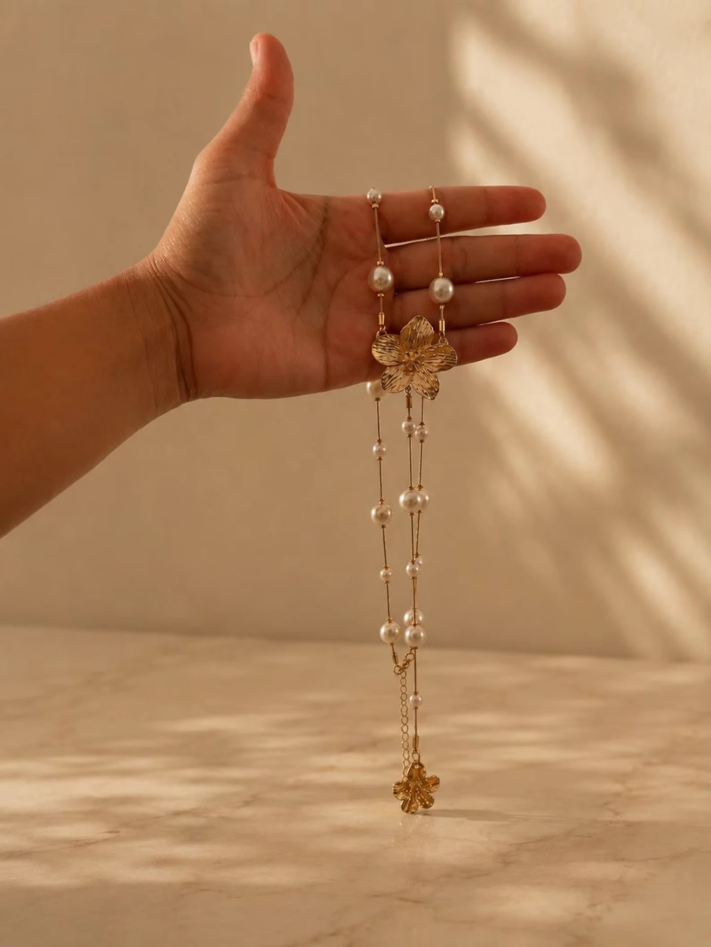 Hibiscus Flower Pearl Lariat Necklace held in hand